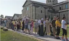 ?? AP PHOTO/CHARLIE RIEDEL ?? People wait to view the body of Sister Wilhelmina Lancaster on Sunday at the Benedictin­es of Mary, Queen of Apostles abbey near Gower, Mo.