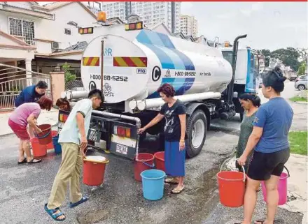  ?? PIC BY FAIZ ANUAR ?? Residents in Lorong Mahkota, Bandar Baru Klang, taking water from a tanker on Thursday.