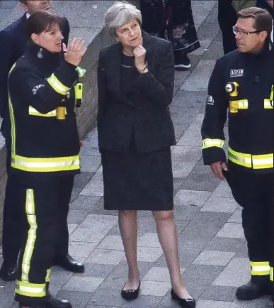  ??  ?? Low profile: Mrs May with fire chief Dany Cotton yesterday. She met none of the residents