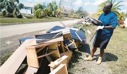  ?? CHRIS O’MEARA/AP ?? Andre McCourt throws away waterlogge­d furniture from his home Tuesday in North Port Residents were cleaning up flooding damage after Hurricane Ian came ashore last week.