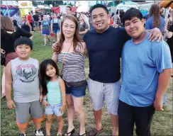  ?? Photo by Joseph B. Nadeau ?? Thoranong Khong of Woonsocket and his wife, Katrina, took their children, sons Xavier and Xaidyn and daughter Natalie, to the opening night of the Our Lady Queen of Martyrs Parish Festival Wednesday.