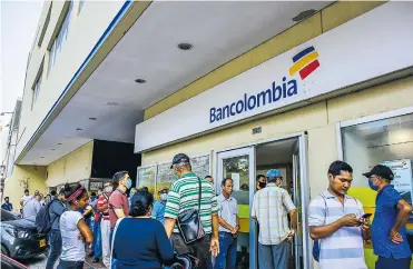  ?? MERY GRANADOS ?? Barranquil­leros se volcaron hasta las sedes bancarias en el último día previo a la cuarentena nacional.