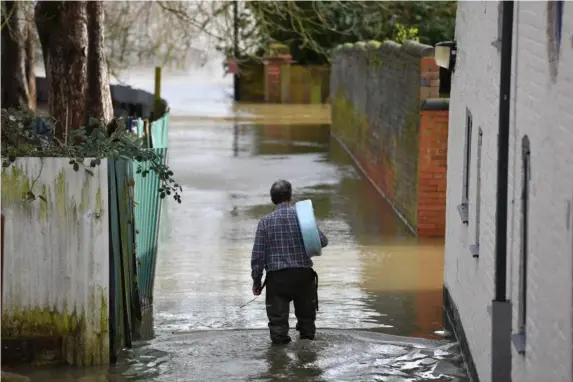  ??  ?? A man heads back to his property in Shrewsbury this week (PA)