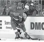  ?? DUANE BURLESON/AP ?? Blue Jackets center Alexandre Texier tries to tie up Red Wings center Michael Rasmussen during the first period at Little Caesars Arena on Tuesday.