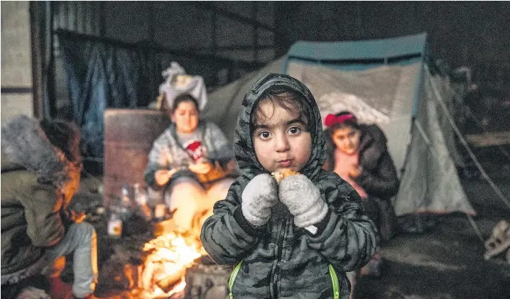  ??  ?? An Iraqi family, below, settle around a fire in a makeshift camp at old farm buildings near Dunkirk. Their main hope is a boat crossing to the UK