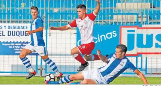  ?? MIGUEL ÁNGEL GONZÁLEZ ?? Raúl Vidal, duda por un proceso gripal, se lanza para cortar el avance de un jugador del Ubrique en el partido de la primera vuelta.