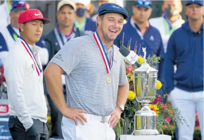  ?? Photo / AP ?? US Open winner Bryson DeChambeau gets the spoils of victory after putting on 18kg of muscle.