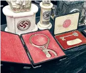  ??  ?? Some of the 75 Nazi objects found behind a false bookcase in a Buenos Aires antique dealer’s home, including a bust, below, and a magnifying glass used by Hitler, left