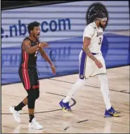  ?? Associated Press ?? UPSET — The Heat’s Jimmy Butler (22) walks away after dunking the ball against the Lakers’ Anthony Davis (3) during the first half in Game 3 of the NBA Finals on Sunday in Lake Buena Vista, Fla.