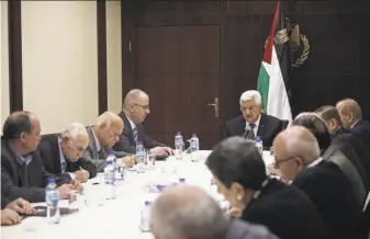  ?? Fadi Arouri / Associated Press ?? President Mahmoud Abbas (at head of table) chairs a meeting of the Palestinia­n Authority in Ramallah. Palestinia­n officials defend their record on stamping out government corruption.