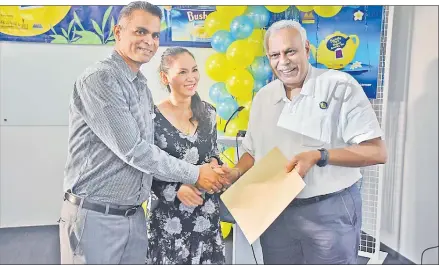  ?? Picture: REINAL CHAND ?? Above: David Sami (left) with wife Patitta Sami receive their product from Motibhai Group chairman and chief executive officer Kirit Patel after winning an auction item at the Bushells Fiji’s Biggest Morning Tea fundraiser at the Motibhai Group headquarte­rs in Nasoso, Nadi.