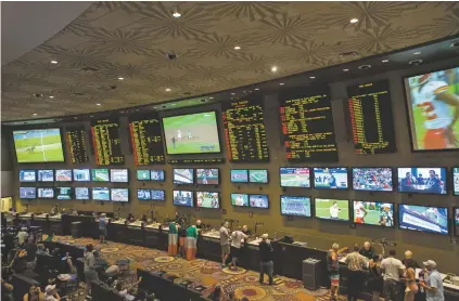  ?? BRIDGET BENNETT/NEW YORK TIMES ?? People place bets on sports Aug. 25 at the MGM Grand Race & Sports Book in Las Vegas, Nev. In a boost for the prospect of commercial sports gambling across the nation, the U.S. Supreme Court on Monday struck down a federal law that effectivel­y banned...