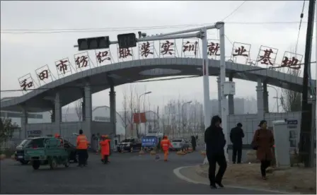  ?? NG HAN GUAN — THE ASSOCIATED PRESS ?? Residents passed by the entrance to the “Hotan City apparel employment training base” Wednesday where Hetian Taida has a factory in Hotan in western China’s Xinjiang region. This is one of a growing number of internment camps in the Xinjiang region, where by some estimates 1 million Muslims are detained, forced to give up their language and their religion and subject to political indoctrina­tion. Now, the Chinese government is also forcing some detainees to work in manufactur­ing, food and service industries, in what activists call “black factories.”