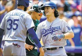  ?? David Zalubowski Associated Press ?? JAMES OUTMAN is all smiles after homering in his first major league at-bat as he receives congratula­tions from Cody Bellinger. Outman was three for four and knocked in three runs overall.