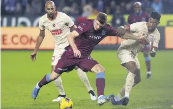  ??  ?? Trabzonspo­r’s Alexander Sorloth (C) tries to dribble past Galatasara­y’s Ryan Donk (R) and Marcao during a Süper Lig match in Trabzon, Turkey, Dec. 1, 2019.