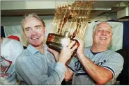  ?? FILE — THE ASSOCIATED PRESS ?? Los Angeles Dodgers manager Tommy Lasorda, right, and Fred Claire, Dodger Vice President, hoist the World Series trophy following their team’s 5-2 win over the Oakland Athletics in Oakland in this Oct. 20, 1988, file photo. Lasorda, the fiery Hall of Fame manager who guided the Los Angeles Dodgers to two World Series titles and later became an ambassador for the sport he loved during his 71 years with the franchise, has died. He was 93.