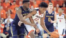  ??  ?? Virginia guard De’Andre Hunter (12) is fouled by Notre Dame forward Juwan Durham during the second half of a game in Charlottes­ville, Va.