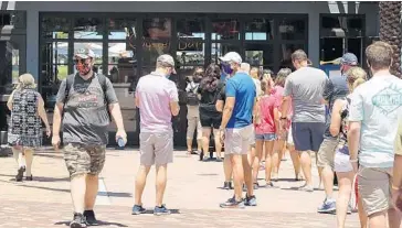  ?? STEPHEN M. DOWELL/ORLANDO SENTINEL ?? Guests wait in line to get into the Boathouse at Disney Springs in Orlando on May 20.