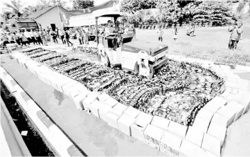  ?? — AFP photo ?? Indonesian police destroy thousands of bottles of illegal homemade alcohol during a public display in South Tangerang.