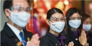  ?? — Xinhua ?? Changing landscape: Workers welcome customers at a shopping mall in Bangkok. Thailand is mulling reopening its door to internatio­nal tourists through travel bubbles.