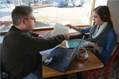  ?? Michael Sears/ Milwaukee
Journal Sentinel/TNS ?? ABOVE: Jim Zaffiro, left, and his
daughter Emily Zaffiro, 17, work on filling out a FAFSA form, which determines how much and what types of financial aid students are eligible for when starting college.