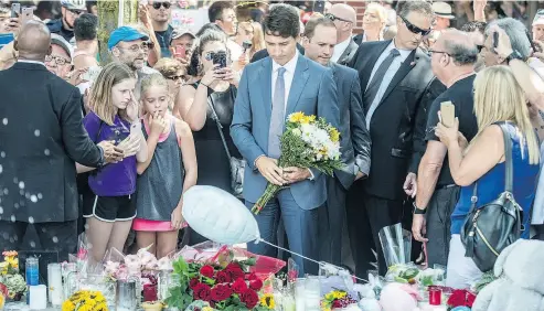  ?? PETER J. THOMPSON / NATIONAL POST ?? Prime Minister Justin Trudeau places flowers at a makeshift memorial on Toronto’s Danforth Avenue on Monday for victims of last Sunday’s shooting spree. “Obviously there’s a lot of strong emotions going on,” he said.