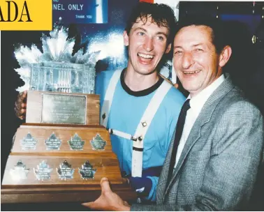  ?? EDMONTON SUN/QMI AGENCY ?? Edmonton Oilers captain Wayne Gretzky poses with his father Walter and the Conn Smythe Trophy in the dressing
room after the Oilers won their fourth Stanley Cup Championsh­ip on May 30, 1985, at the Northlands Coliseum.