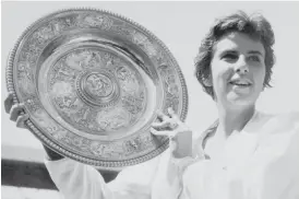  ?? AP ?? Maria Bueno of Brazil holds up the trophy after winning the women’s singles final at Wimbledon. She won three Wimbledon and four U. S. Open singles titles in her career.