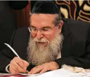  ??  ?? Rabbi Heshy Pincus, writes the first sentence of a new Torah commission­ed by the Meyerland Minyan synagogue, which lost a Torah due to flooding.