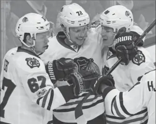  ?? GENE J. PUSKAR, THE ASSOCIATED PRESS ?? Chicago’s Artemi Panarin (72) celebrates his goal with Tanner Kero (67) and Patrick Kane against the Penguins in Pittsburgh on Wednesday. Chicago won, 5-1. For complete coverage, see therecord.com.