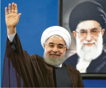  ?? Foto: A. Kenare, afp ?? Grund zur Freude? Der iranische Präsident vor dem Konterfei des religiösen Führers Ajatollah Khamenei.