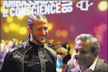  ?? Peter Dejong The Associated Press ?? Former NFL quarterbac­k and activist Colin Kaepernick, left, talks Saturday to Amnesty Internatio­nal Secretary General Salil Shetty after receiving the Amnesty Internatio­nal Ambassador of Conscience Award for 2018 in Amsterdam.