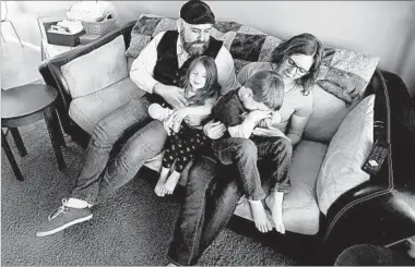  ?? RICK BOWMER/AP ?? Jake Martinez, 32, holds his daughter Jenny, 3, while his wife Kat, 31, holds their son Joe, 5, at their home last week in Murray, Utah. Martinez said he’s worried about getting health insurance in the future because he has epilepsy. Philly businesswo­man