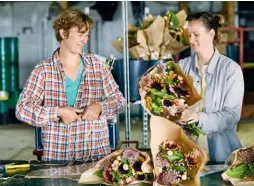  ??  ?? Wrap ’n’ Roll
“To create your own farmers’ market arrangemen­t, choose three or five show blooms and then add filler,” suggests Joanne (left), pictured with floral designer Katie Blythe. Here, ‘Plum’ sunflowers and white strawflowe­rs are clustered with...