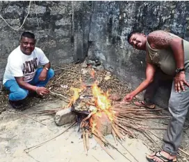  ??  ?? Hungry bikers Kumareasan Ramakrishn­an (right) and Janarthana­n Rajalingam starting a fire to barbecue crabs for a meal.