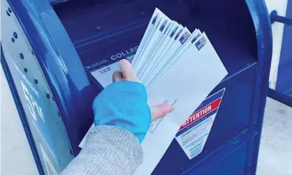  ?? Photograph: Courtesy Vote Forward ?? Vote Forward volunteer Elizabeth Hildebrand drops letters bound for Georgia into a mailbox.