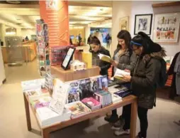  ?? RENÉ JOHNSTON/TORONTO STAR ?? From left, Nicole Milo, Gabby Scala and Alexis Walker check out the books on display at Page & Panel in the Toronto Reference Library.