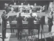  ?? ANDREW VAUGHAN THE CANADIAN PRESS ?? Pallbearer­s remove the Canadian flags from the caskets at the regimental funeral for constables Robb Costello and Sara Burns, who were killed in the line of duty, in Fredericto­n on Saturday.