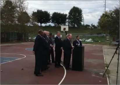  ?? ROSE QUINN – DIGITAL FIRST MEDIA ?? Officials announce funding for a Delaware County Gun Violence Task Force on basketball court at the Bennett Homes in Chester, scene of a multiple shooting last weekend. Shots were fired on the crowded court from the bridge in the background.