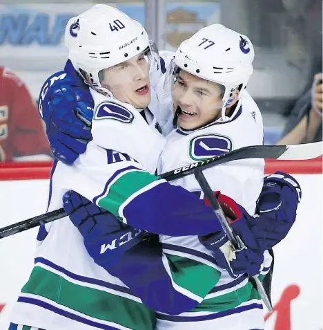  ?? JEFF MCINTOSH/THE CANADIAN PRESS ?? Vancouver Canuck Elias Pettersson, left, celebrates his goal with teammate Nikolay Goldobin during Saturday’s game against the Flames in Calgary. The two, along with Loui Eriksson, have formed the Canucks’ most reliable line in the early going this season