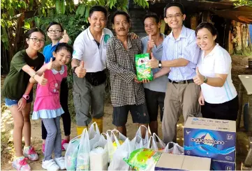  ??  ?? Chai (second right) hands over food items to Lai (fourth right), in the presence of Wan (fifth right) and other volunteers.