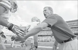  ?? JOSH HOLMBERG/ LAS VEGAS REVIEW-JOURNAL ?? UNLV coach Bobby Hauck greets wide receiver Anthony Williams on Thursday before the opening kickoff of the Rebels’ 51-23 loss to Minnesota at TCF Bank Stadium. The loss was UNLV’s 23rd straight on the road.