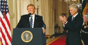  ?? (Kevin Lamarque/Reuters) ?? US PRESIDENT Donald Trump announces his nomination of Neil Gorsuch to be an associate justice of the Supreme Court, as Gorsuch applauds, at the White House on Tuesday.