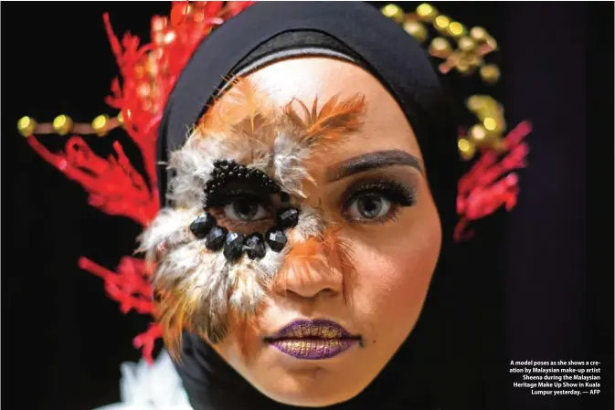  ?? — AFP ?? A model poses as she shows a creation by Malaysian make-up artist Sheena during the Malaysian Heritage Make Up Show in Kuala Lumpur yesterday.