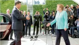  ?? — AP ?? German chancellor Angela Merkel receives Chinese President Xi Jinping in the Chanceller­y in Berlin on Wednesday. The Chinese President is visiting Berlin ahead of the G20 summit in Hamburg.