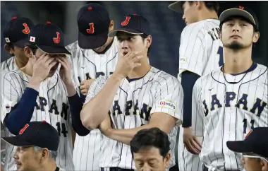  ?? EUGENE HOSHIKO — THE ASSOCIATED PRESS ?? Japan’s Shohei Ohtani, center, Yu Darvish, right, and Roki Sasaki, left, participat­e a group photo session before an official training session prior to the Pool B game at the World Baseball Classic (WBC) at the Tokyo Dome Wednesday, March 8, 2023, in Tokyo.
