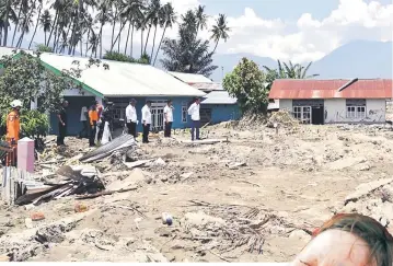  ??  ?? This handout picture shows Widodo (right) with a local official as he gets a close-up look at the damage caused by earthquake and tsunami in Palu.