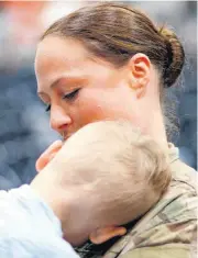  ??  ?? Staff Sgt. Jenna Hudgins hugs her son, Dylan Hudgins, 2, after the departure ceremony for more than 160 members of the 1345 Transporta­tion Company, 90th Troop Command, Oklahoma Army National Guard.