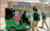  ?? PTI ?? Police officers restrict a rickshaw driver defying the nation-wide lockdown to curb the spread of the Coronaviru­s in Hyderabad, Pakistan on Friday