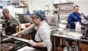  ?? Nick Sambides/Hearst Connecticu­t Media ?? Cook Monica Santillan, center, and cook Marcelo Pachero, left, with manager Diego Goldstein in the kitchen of new Milford restaurant Chimichurr­i.